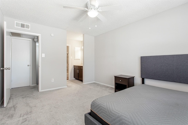 carpeted bedroom with ceiling fan, ensuite bathroom, and a textured ceiling