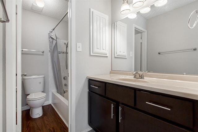 full bathroom featuring shower / tub combo with curtain, hardwood / wood-style flooring, vanity, toilet, and a textured ceiling