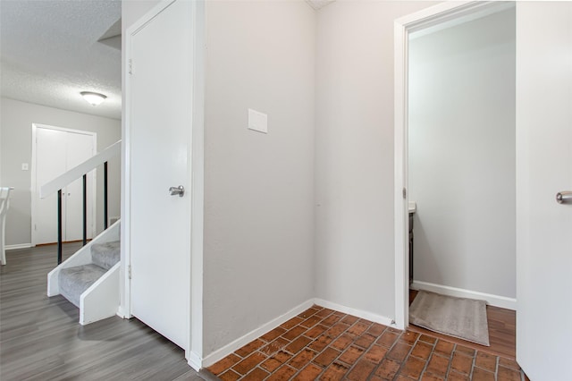 hall featuring dark hardwood / wood-style floors and a textured ceiling