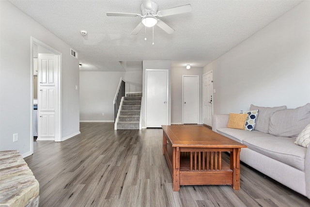 unfurnished living room featuring ceiling fan, hardwood / wood-style floors, and a textured ceiling