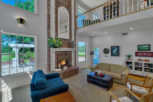 carpeted living room featuring a fireplace and a high ceiling