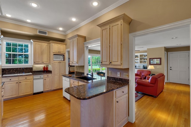 kitchen with sink, kitchen peninsula, light brown cabinets, white appliances, and light hardwood / wood-style flooring