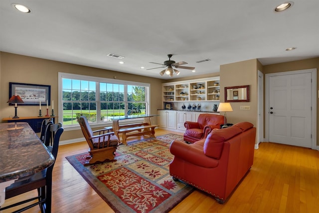 living room with light hardwood / wood-style floors and ceiling fan