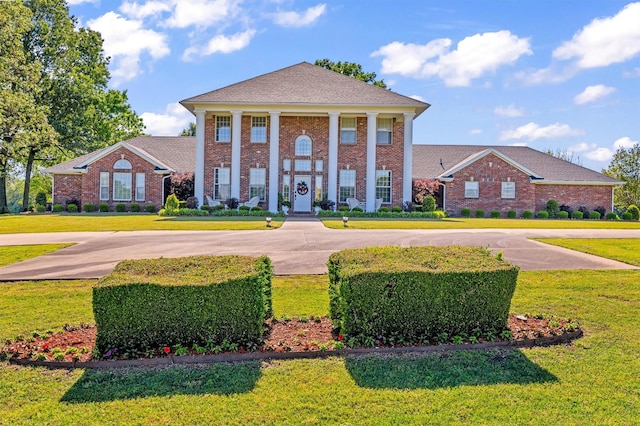 greek revival inspired property with a front yard