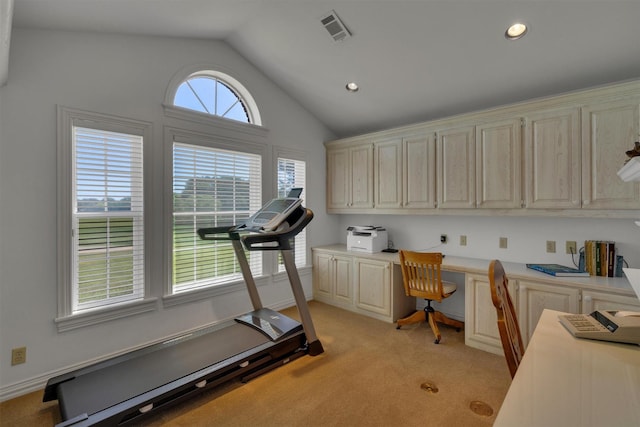 workout area with lofted ceiling, built in desk, and light carpet