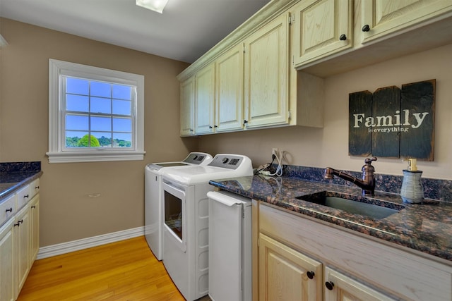 laundry room featuring cabinets, sink, independent washer and dryer, and light hardwood / wood-style floors