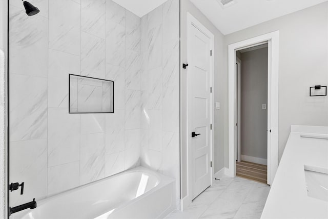 bathroom with tiled shower / bath combo and vanity