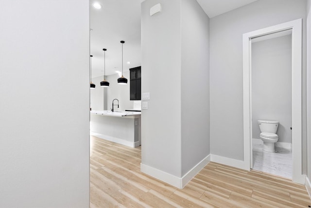 hallway with sink and light hardwood / wood-style flooring