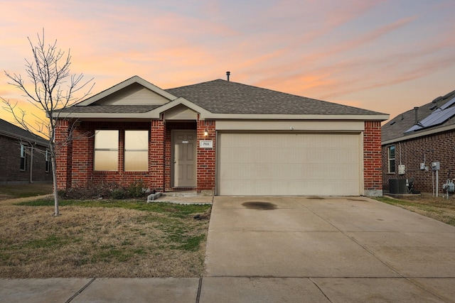 ranch-style house featuring a garage and central AC