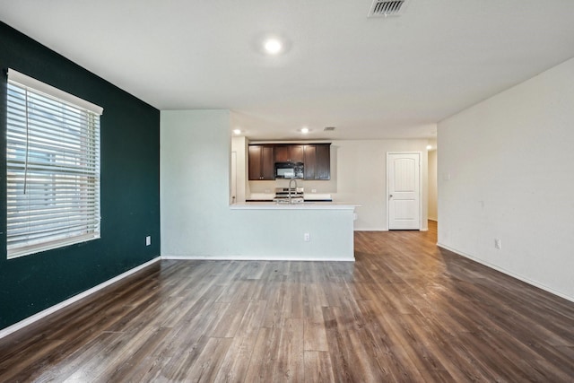 unfurnished living room featuring dark hardwood / wood-style floors and sink