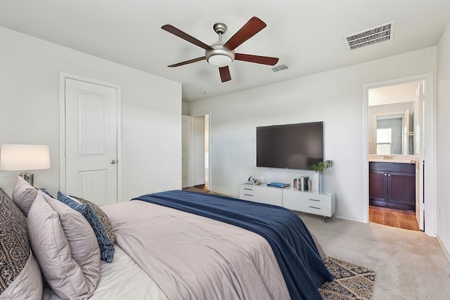 bedroom featuring ensuite bathroom, carpet floors, and ceiling fan