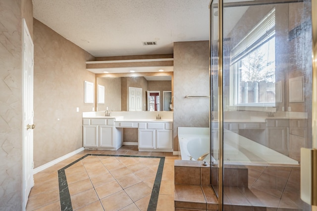 bathroom with vanity, tile patterned flooring, plenty of natural light, and a textured ceiling