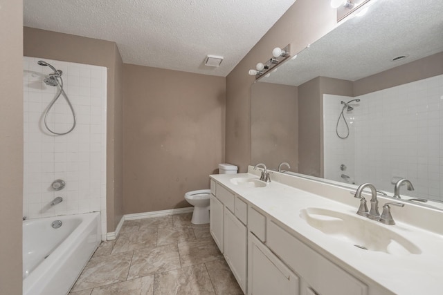 full bathroom featuring tiled shower / bath combo, vanity, a textured ceiling, and toilet