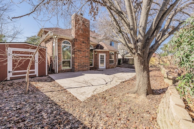 back of house featuring a patio area and a storage shed