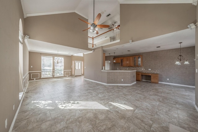 unfurnished living room featuring ceiling fan with notable chandelier and high vaulted ceiling