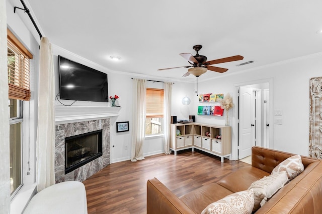 living room with ceiling fan, ornamental molding, dark hardwood / wood-style floors, and a premium fireplace