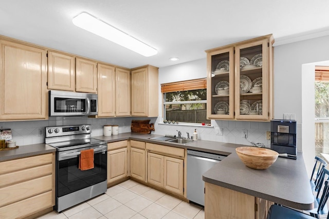 kitchen featuring light brown cabinetry, sink, backsplash, light tile patterned floors, and stainless steel appliances