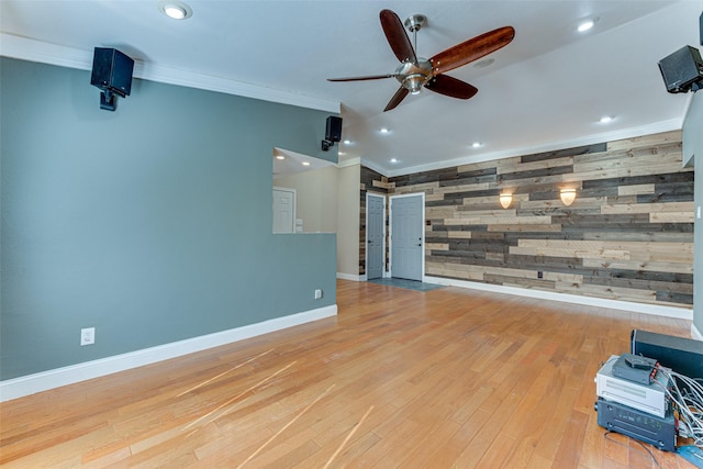 unfurnished living room featuring ceiling fan, ornamental molding, and light hardwood / wood-style flooring