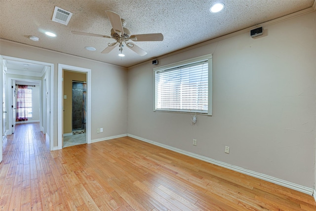 unfurnished room featuring crown molding, light hardwood / wood-style floors, and a textured ceiling