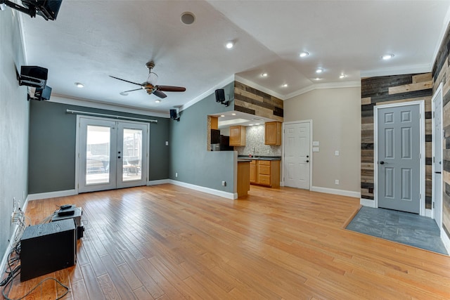 unfurnished living room with french doors, lofted ceiling, crown molding, ceiling fan, and light hardwood / wood-style floors