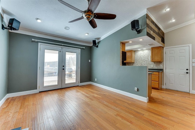 unfurnished living room featuring french doors, lofted ceiling, crown molding, light wood-type flooring, and ceiling fan