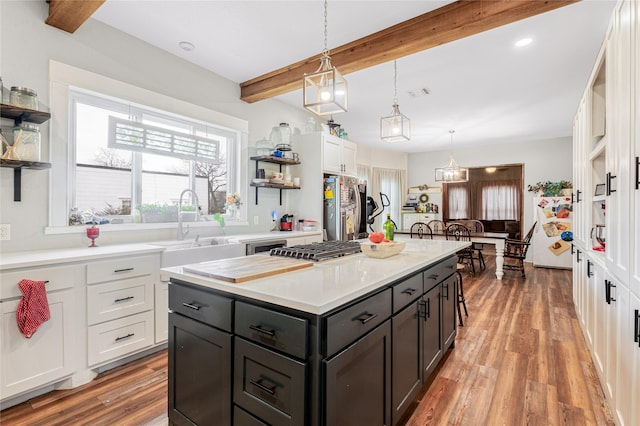 kitchen with open shelves, light wood finished floors, beamed ceiling, white cabinets, and freestanding refrigerator