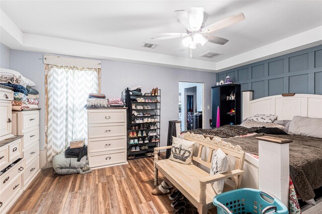 bedroom featuring light wood-type flooring, visible vents, and a ceiling fan