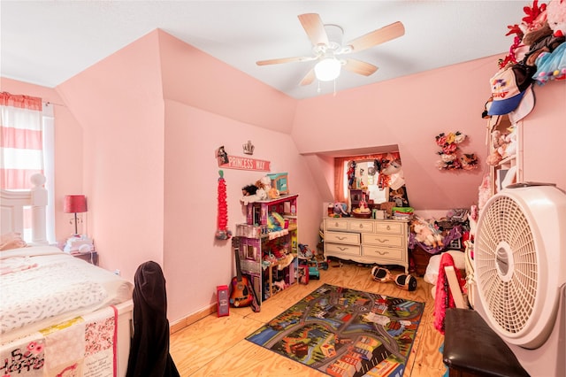 bedroom with vaulted ceiling, a ceiling fan, and wood finished floors
