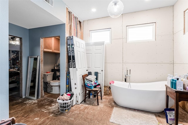 full bathroom featuring a soaking tub, visible vents, and toilet