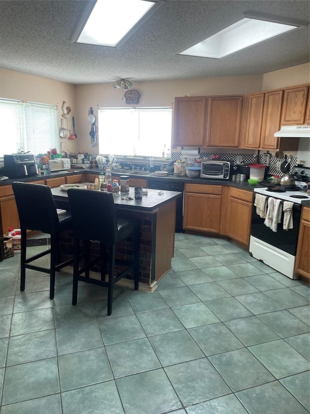 kitchen with range with electric cooktop, plenty of natural light, tasteful backsplash, and light tile patterned floors