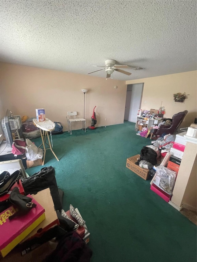 miscellaneous room with ceiling fan, carpet, and a textured ceiling