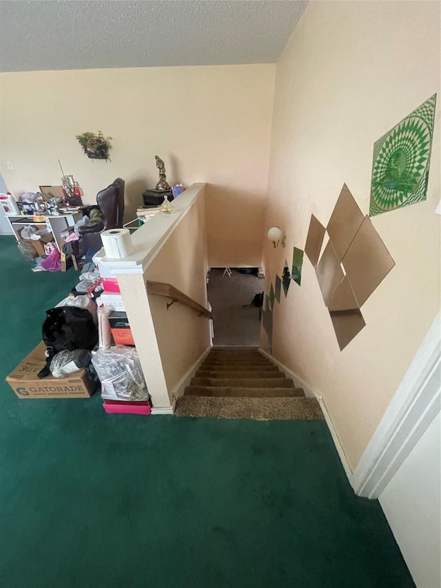 staircase featuring carpet floors and a textured ceiling