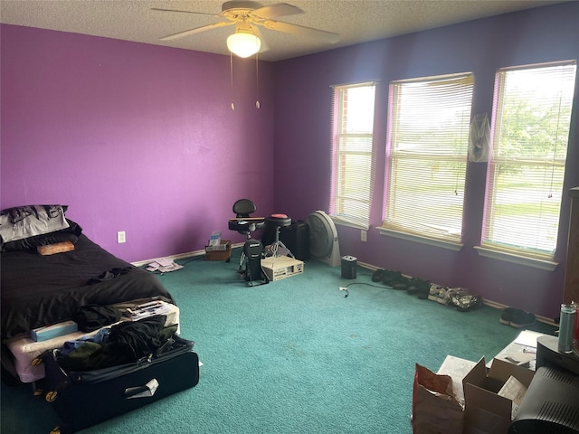 misc room with carpet floors, a healthy amount of sunlight, ceiling fan, and a textured ceiling