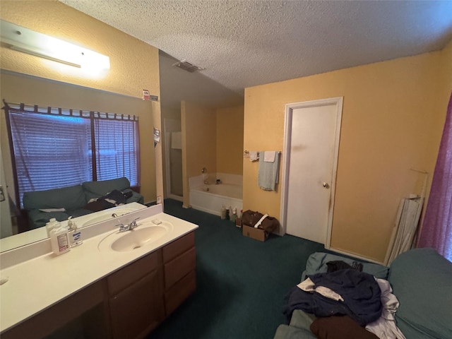 bathroom with vanity, a bathing tub, and a textured ceiling