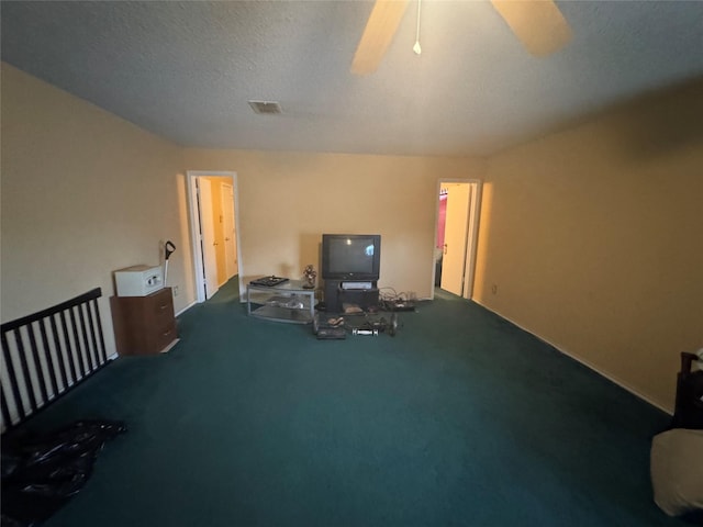 workout area featuring ceiling fan, carpet floors, and a textured ceiling