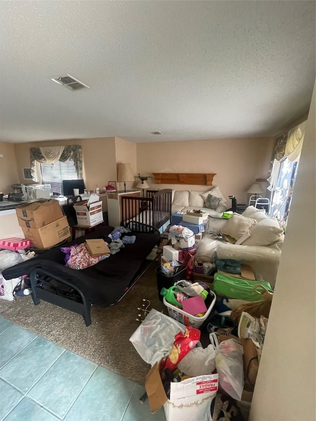 misc room with plenty of natural light, a textured ceiling, and light tile patterned flooring