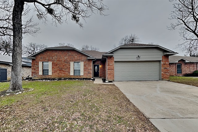 ranch-style home featuring a garage and a front lawn