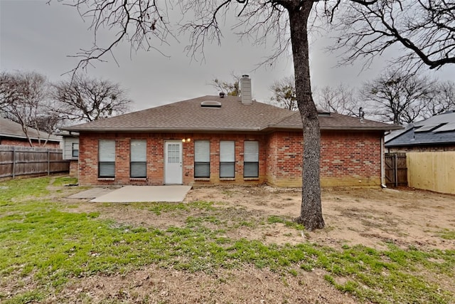 rear view of property featuring a patio and a lawn