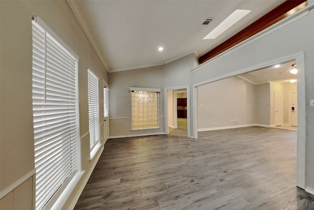 unfurnished room with hardwood / wood-style flooring, vaulted ceiling, and crown molding