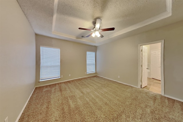 carpeted empty room with ceiling fan, a textured ceiling, and a tray ceiling