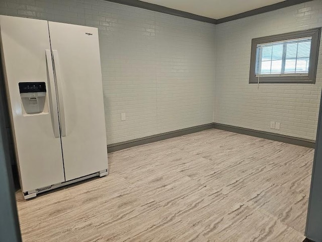 interior space featuring light hardwood / wood-style flooring and brick wall