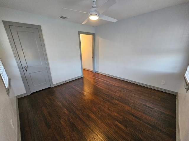 unfurnished bedroom featuring dark wood-type flooring and ceiling fan