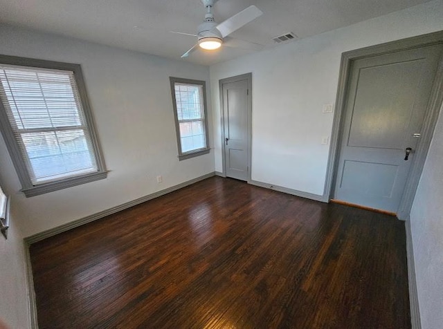 unfurnished room with ceiling fan and dark hardwood / wood-style flooring