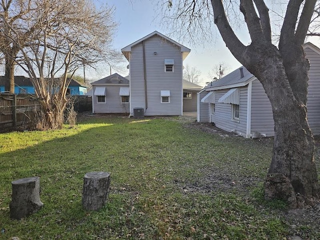 rear view of property featuring a yard and central AC unit