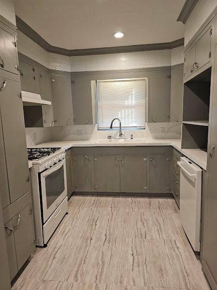 kitchen with light hardwood / wood-style floors, white appliances, gray cabinets, and sink