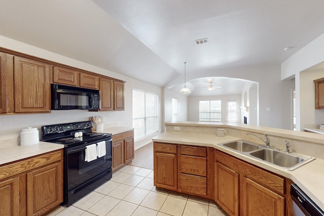 kitchen featuring lofted ceiling, sink, black appliances, light tile patterned flooring, and decorative light fixtures