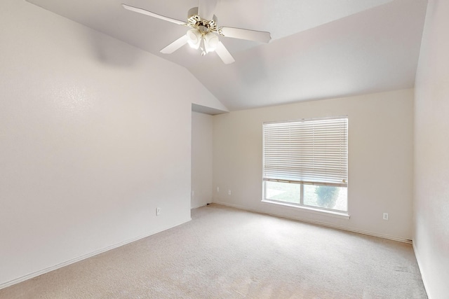 carpeted empty room with vaulted ceiling and ceiling fan