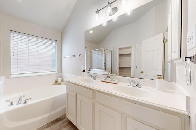 bathroom with independent shower and bath, vanity, lofted ceiling, and hardwood / wood-style floors