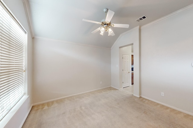 carpeted spare room with vaulted ceiling, ornamental molding, and ceiling fan