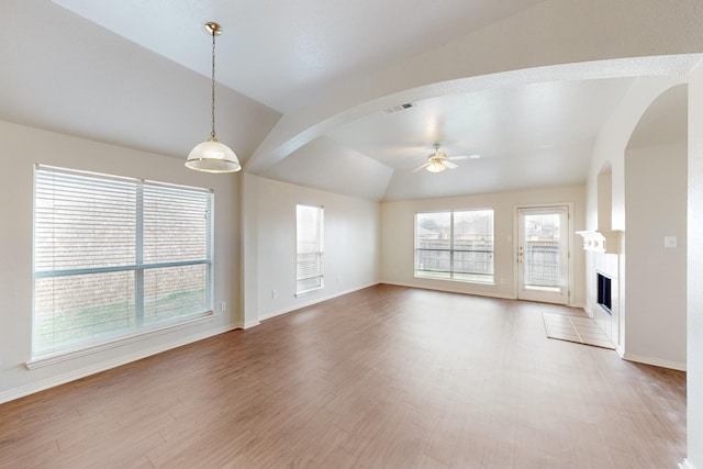 unfurnished living room featuring lofted ceiling, hardwood / wood-style floors, and ceiling fan